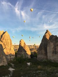 View of rock formations against sky with a horse