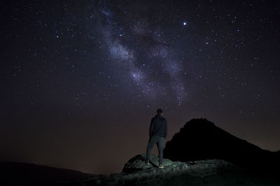 Man standing against sky at night