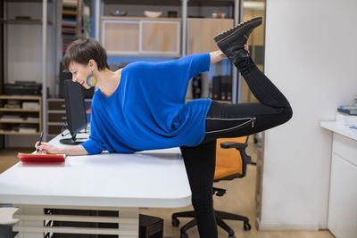 Side view of woman exercising in gym