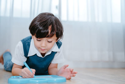 Boy writing in whiteboard at home