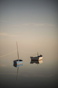 Still boats over pastel sky and empty calm ocean on the seaside