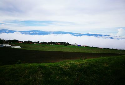 Scenic view of field against cloudy sky