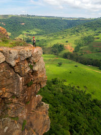 Man standing on rock against landscape