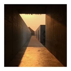 Empty footpath amidst buildings against clear sky