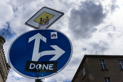 Low angle view of directional road sign against sky