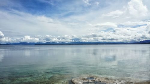 Scenic view of calm sea against cloudy sky