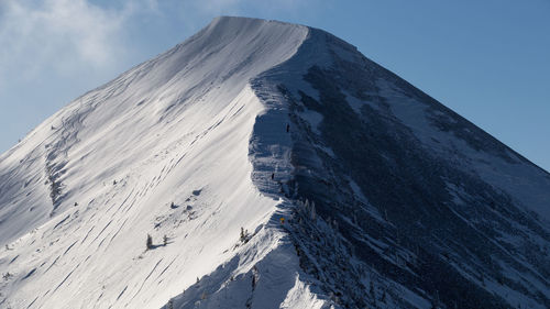 Low angle view of snowcapped mountains against sky