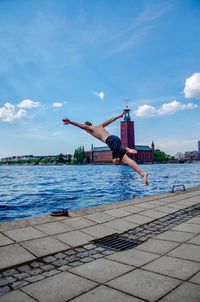 Man jumping in swimming pool against sky