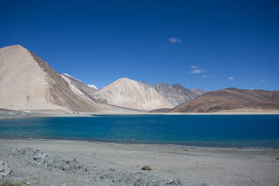 Scenic view of mountains against blue sky