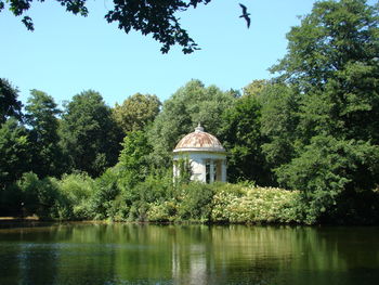 Gazebo by lake against sky