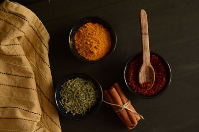 Directly above view of spices and herbs in bowl by napkin on table