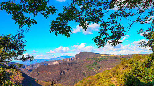 Scenic view of mountains against blue sky