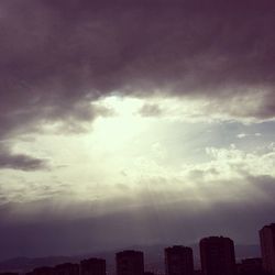 Cityscape against cloudy sky at sunset