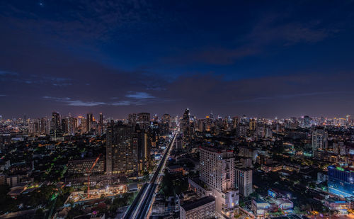 High angle view of illuminated buildings against sky at night