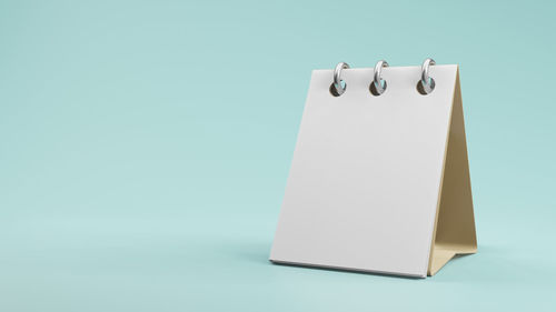 Close-up of paper hanging against white background