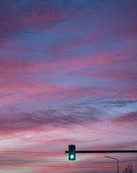 Low angle view of illuminated light against sky at sunset