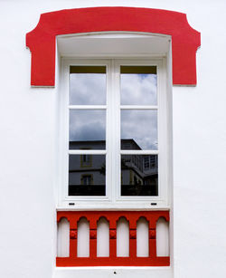 Red window on white wall of building