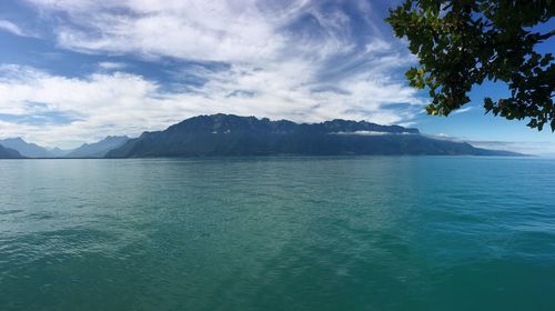 Scenic view of sea and mountains against sky