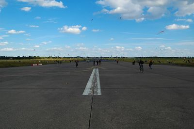 Airplane on airport runway against sky