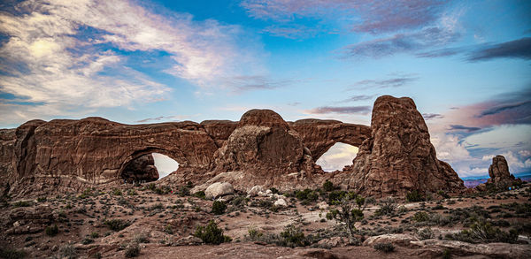 Rock formations against cloudy sky