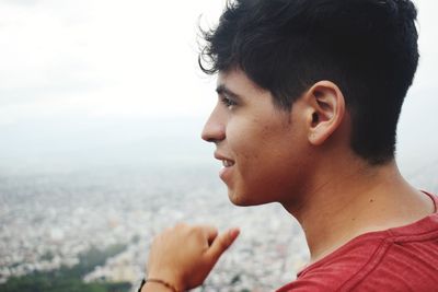 Close-up of young man looking at view against sky