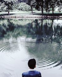 Rear view of silhouette boy swimming in lake