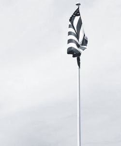 Low angle view of flag waving against sky