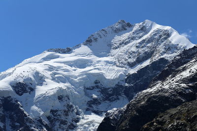 Scenic view of snowcapped mountains against clear blue sky