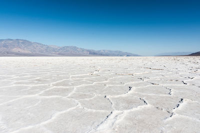 Scenic view of desert against clear blue sky