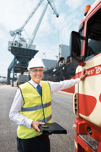 Smiling engineer holding file folder at dock