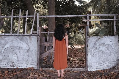 Rear view of woman standing by plants