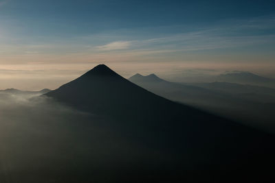 Scenic view of mountains during foggy weather against sky