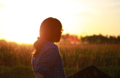 Side view of woman against clear sky during sunset