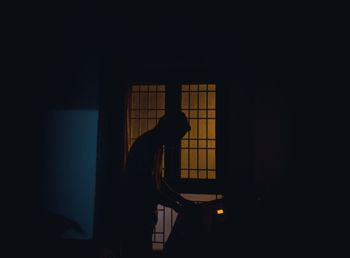 Side view of silhouette man standing in darkroom