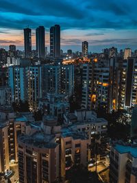 High angle view of illuminated buildings against sky at dusk