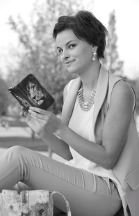 Portrait of young woman holding mobile phone