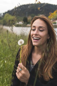 Portrait of smiling young woman against plants