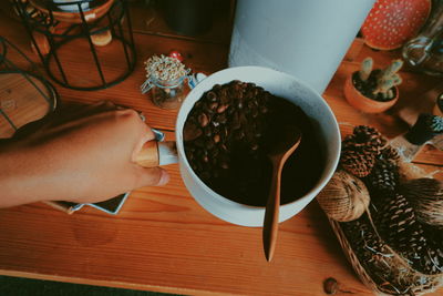 High angle view of hand holding tea cup on table