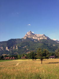 Scenic view of landscape and mountains against clear blue sky