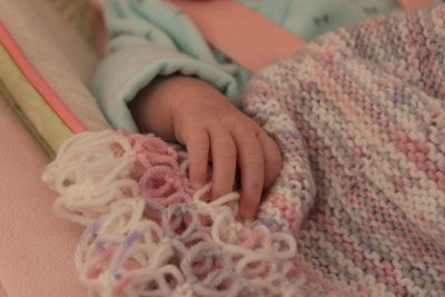 Close-up of baby hand on bed