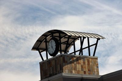 Low angle view of clock against sky