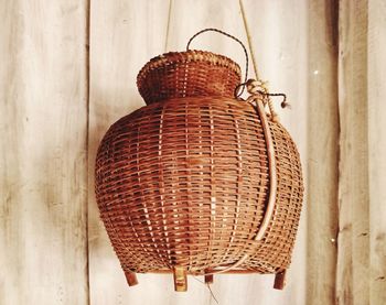 Close-up of wicker basket hanging against wall