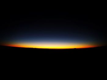 Silhouette landscape against clear sky at night