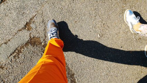 Low section of woman standing on sand