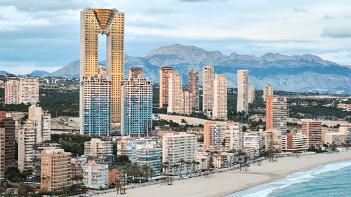 Buildings in city against cloudy sky