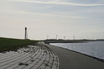 Footpath by sea against sky