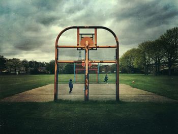 Siblings playing at basketball court