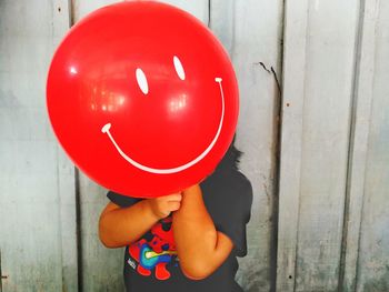 Close-up of hand holding red balloon