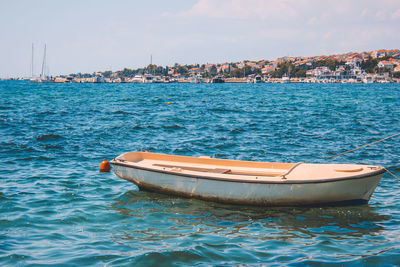 Sailboat moored in sea against sky