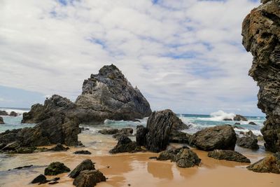 Rocks on beach against sky